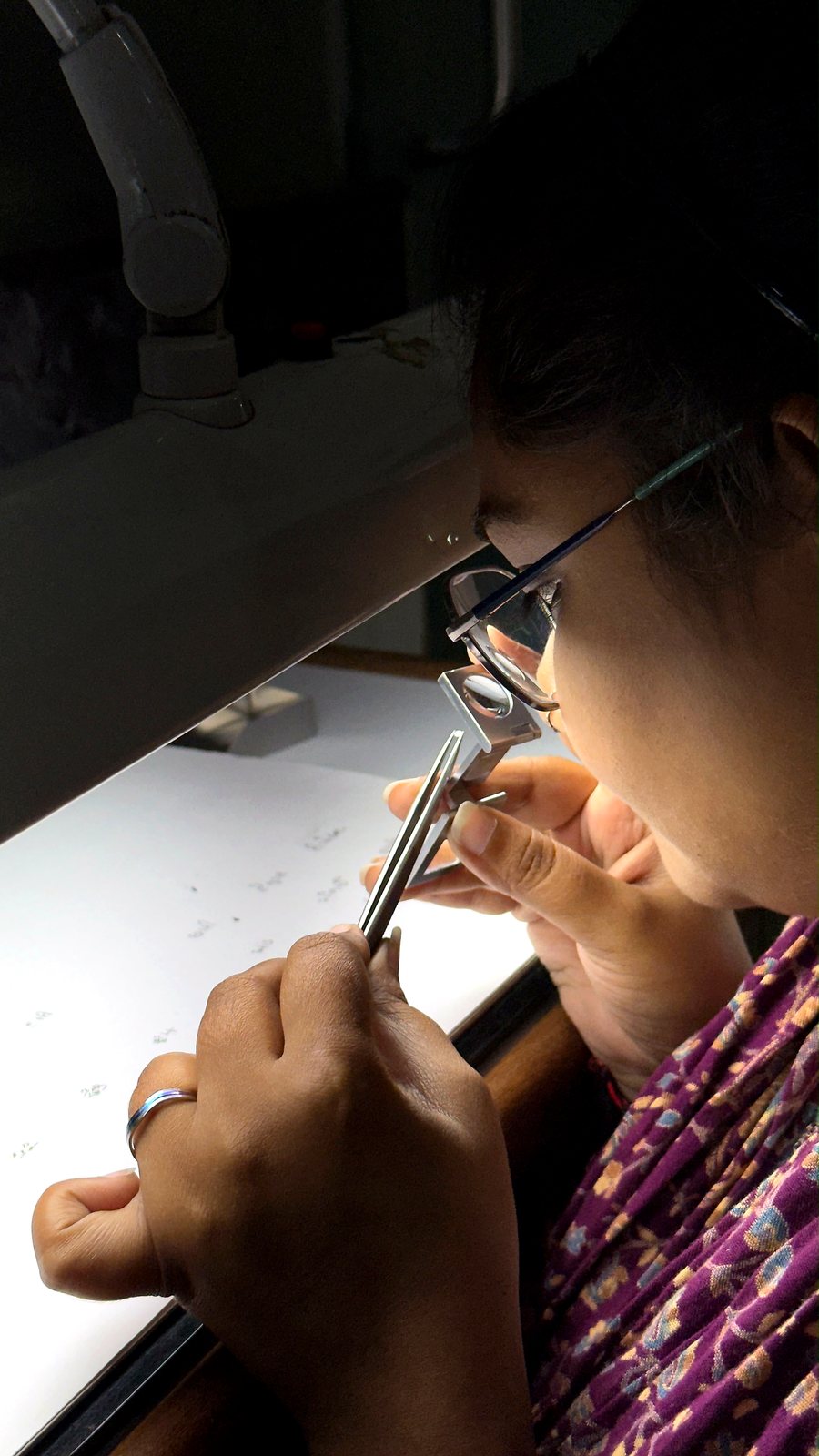 A Sahyog Diamond specialist inspecting a diamond with a loupe